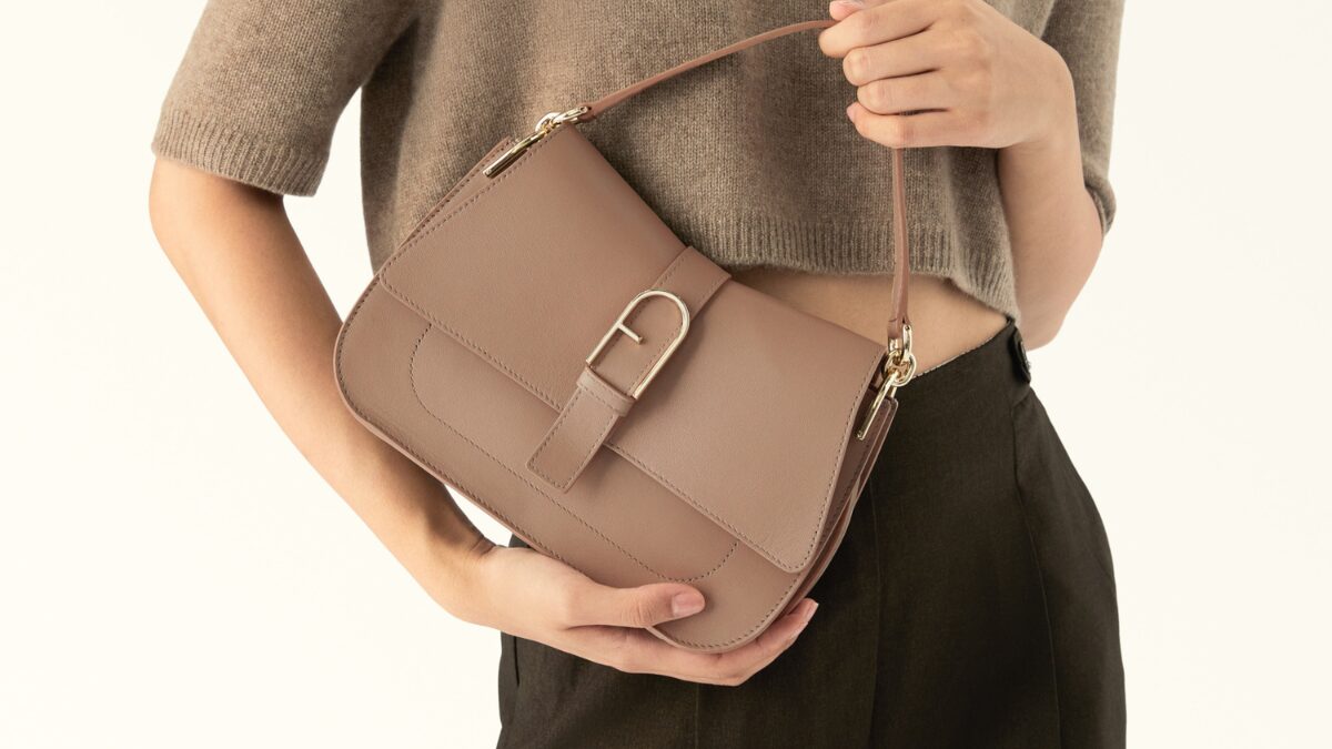 フルラのベージュのハンドバッグを持っている女性